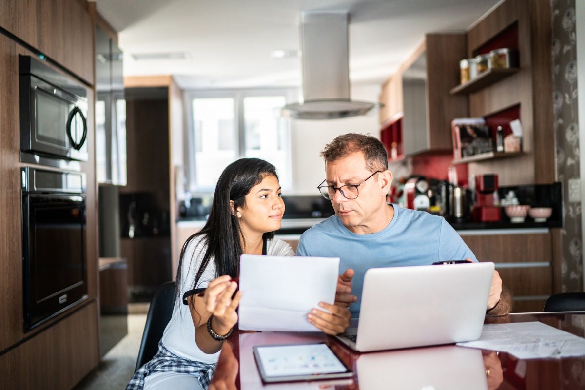 Father and daughter doing home finances together at home