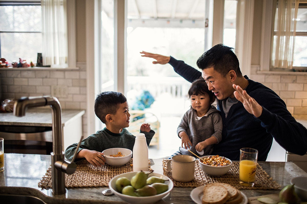 Parent and children sharing breakfast at a kitchen table
