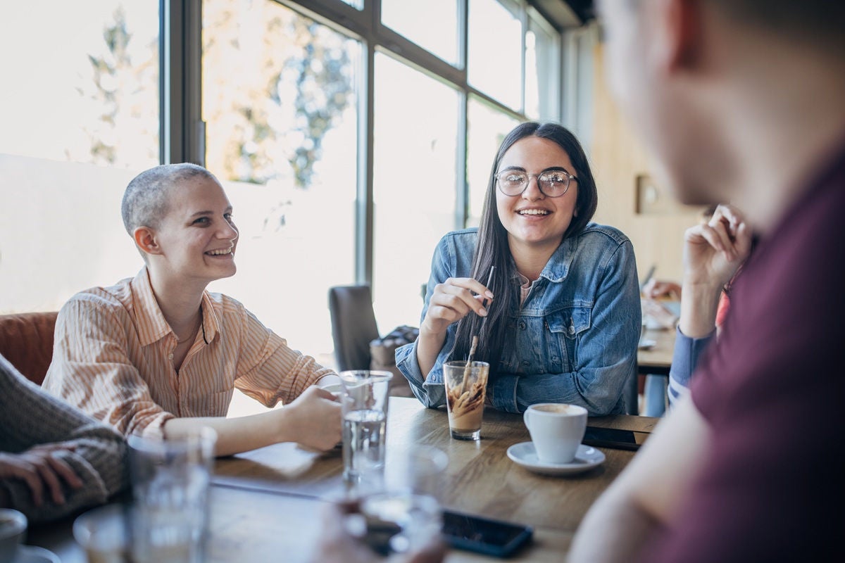 Friends chatting over coffee in a bright modern café
