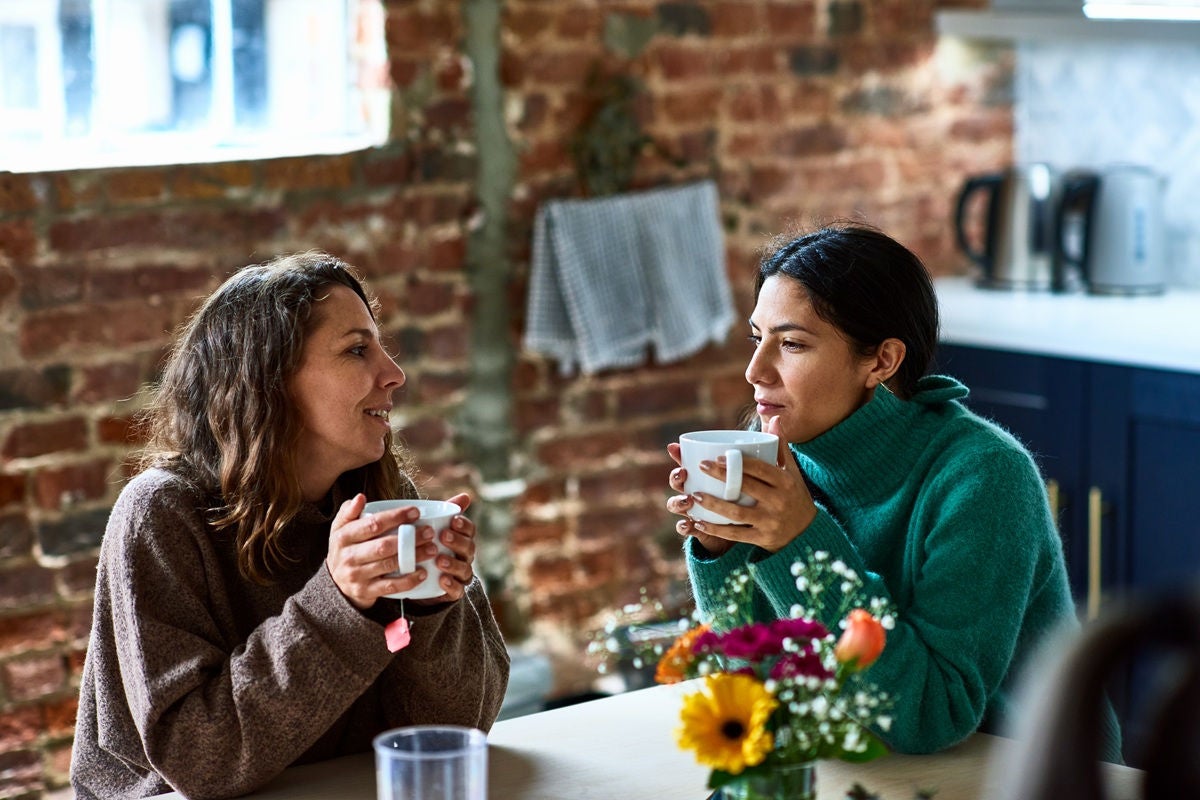 Two women having coffee and talking in a cafe.