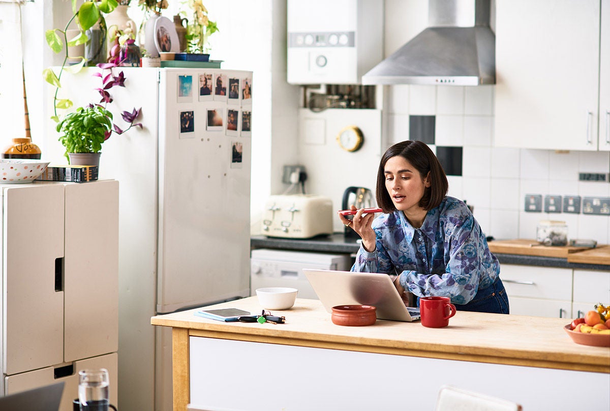 Individual managing personal finances and online banking on tablet at home kitchen