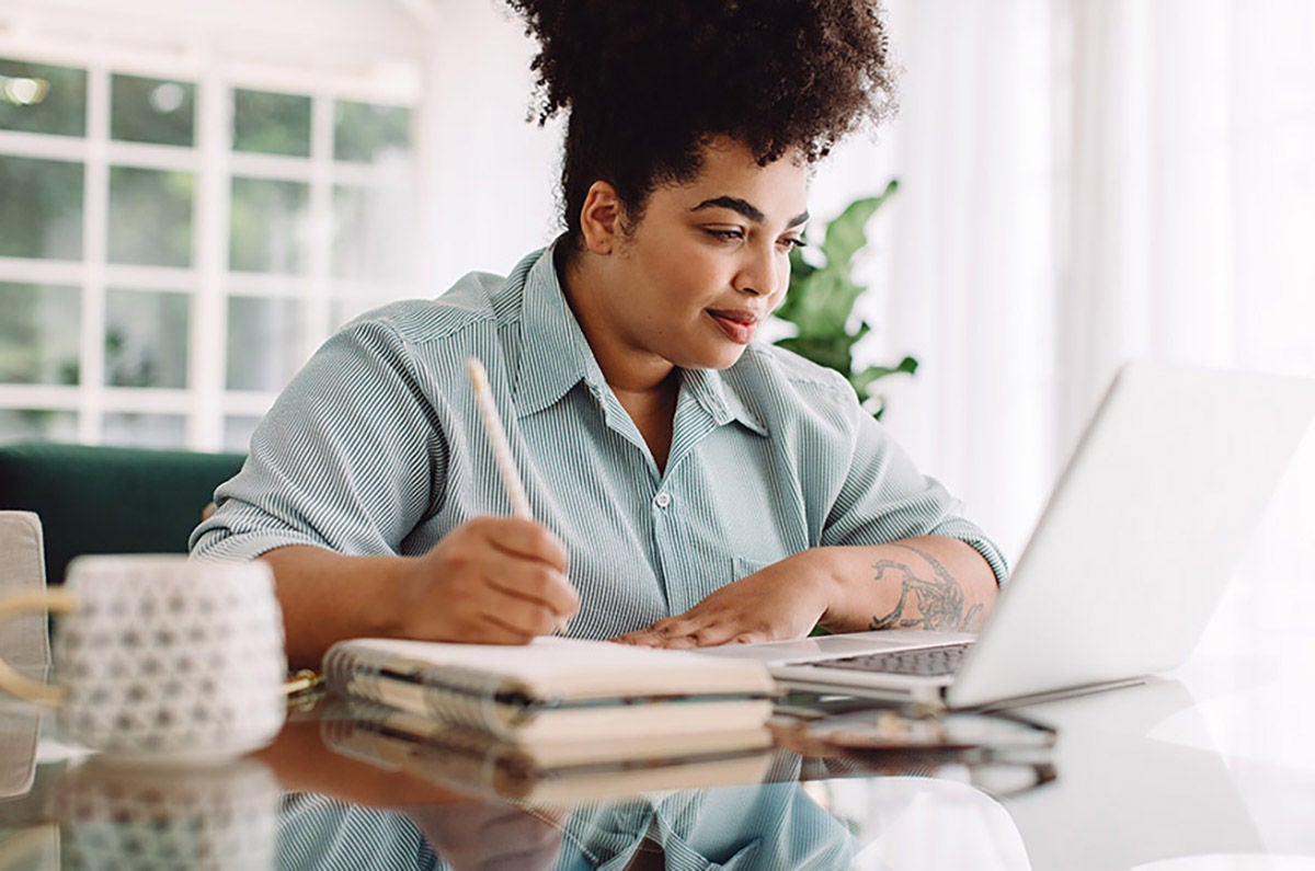 Small business owner managing finances and budgeting on laptop at desk