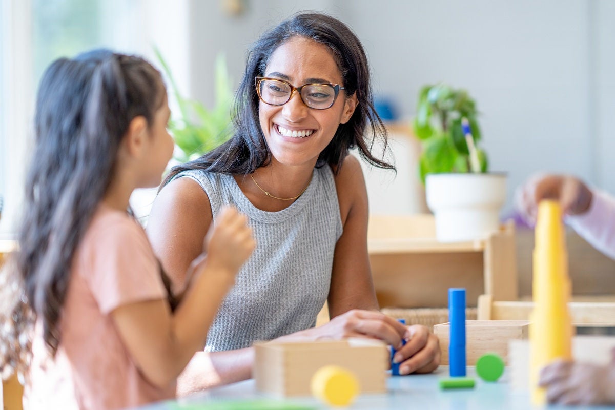 Adult and child engaging in a hands‑on learning activity with educational blocks