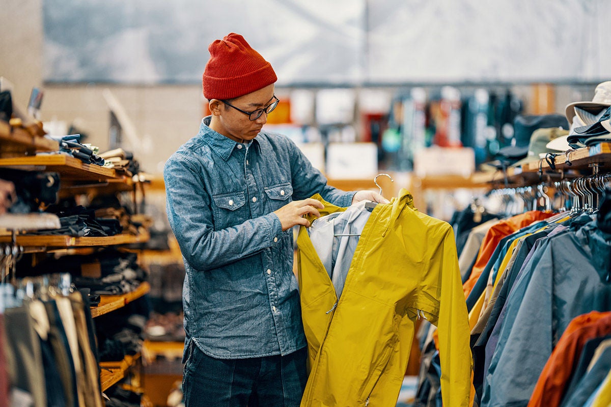 Mid adult retail staff hanging jackets in a clothing store