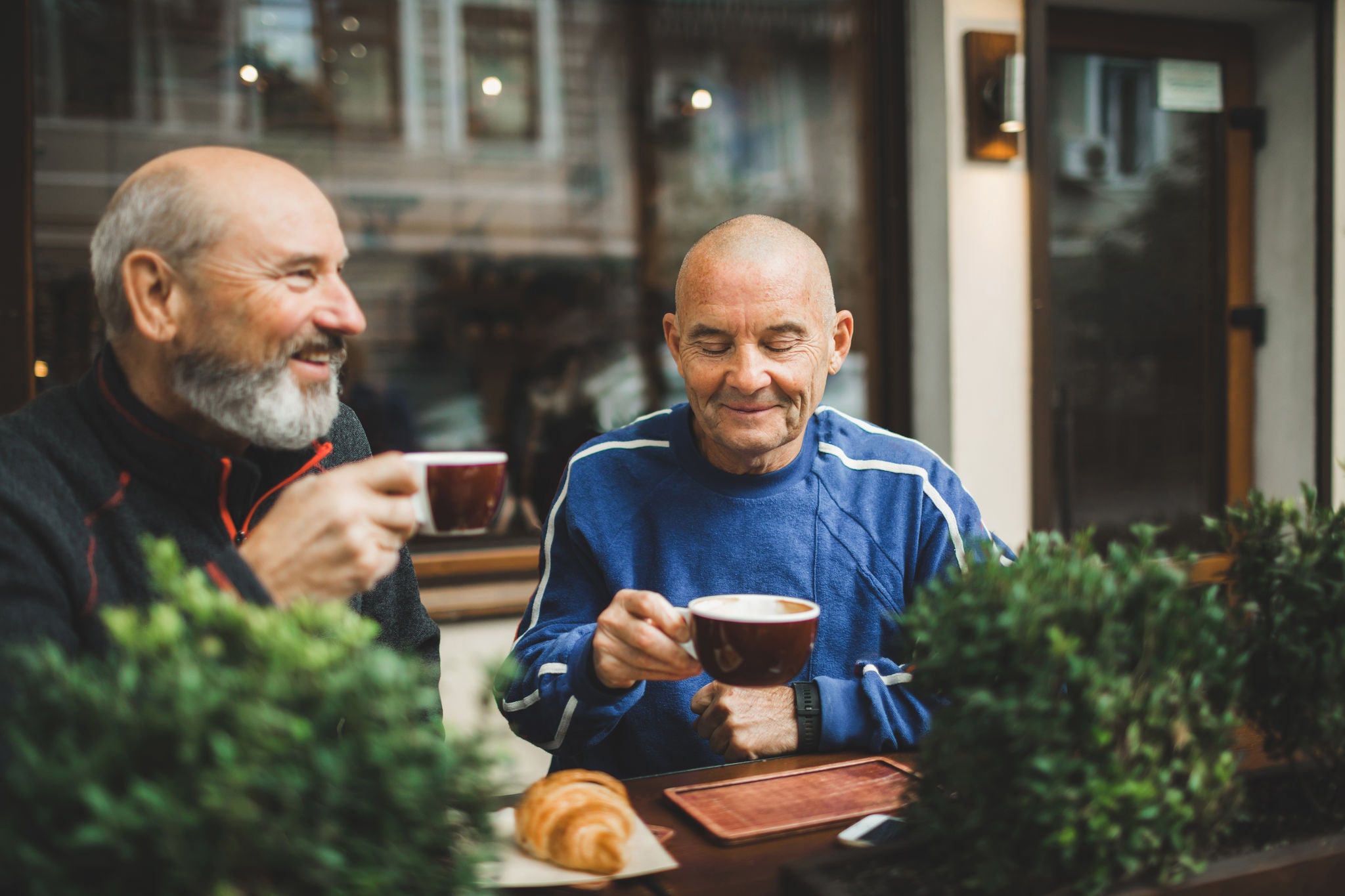 Coffee meetup at a sidewalk café with pastries and drinks between two people