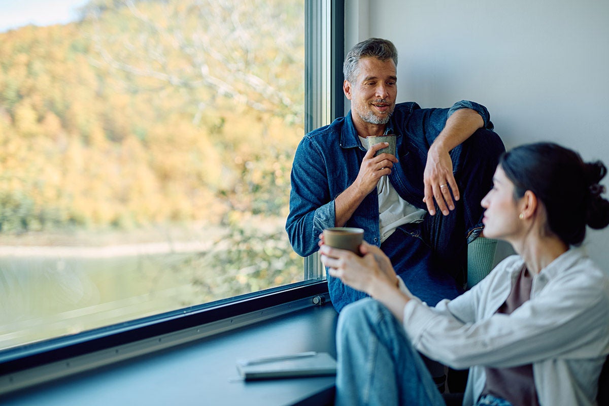 Couple discussing financial goals and lifestyle planning at home by window