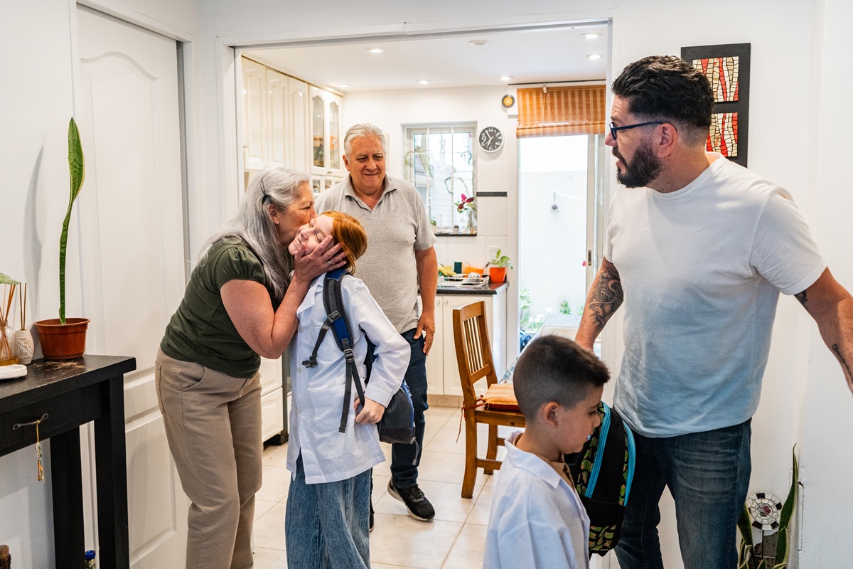Grandparents and parents saying goodbye to kids leaving for school