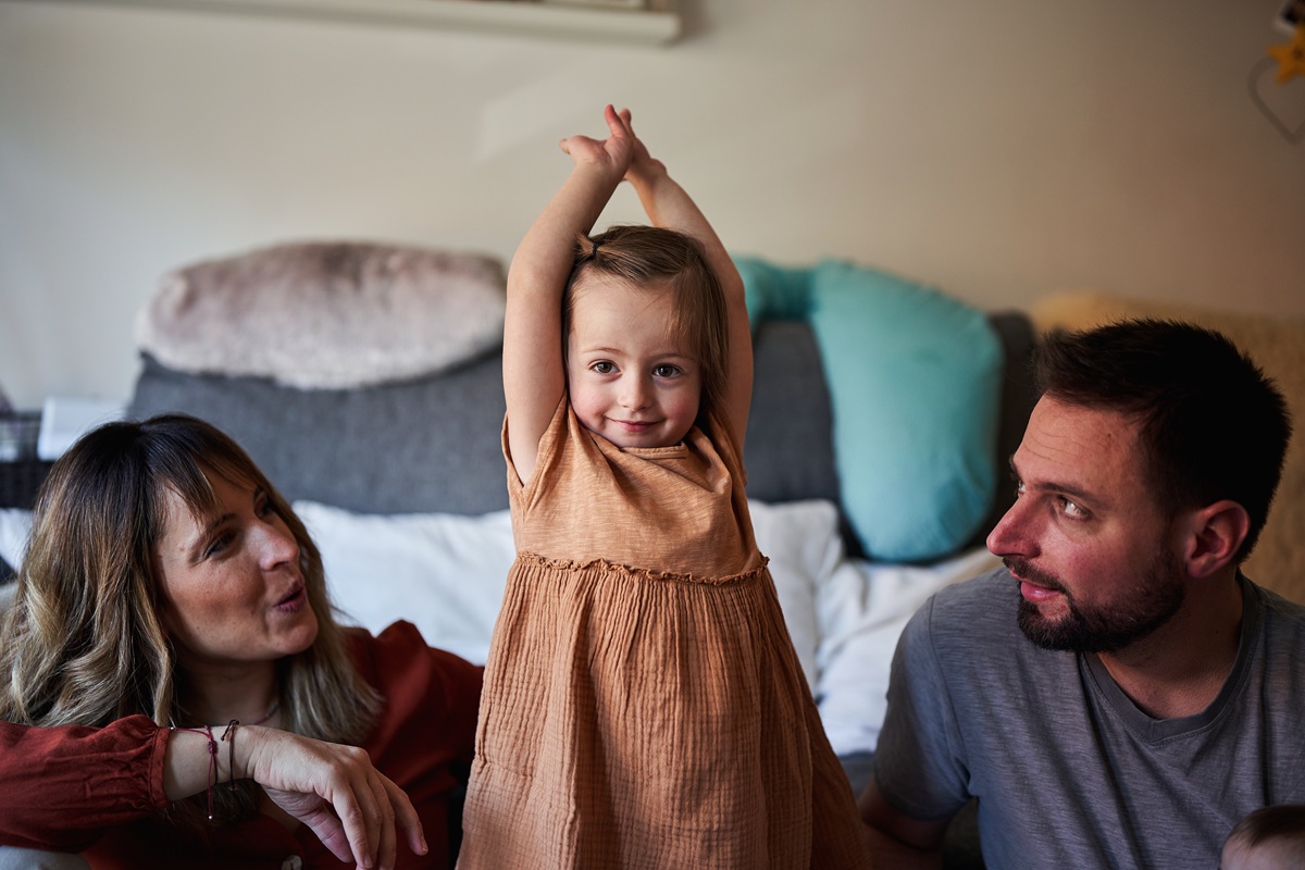 Parents and young child spending time together on sofa