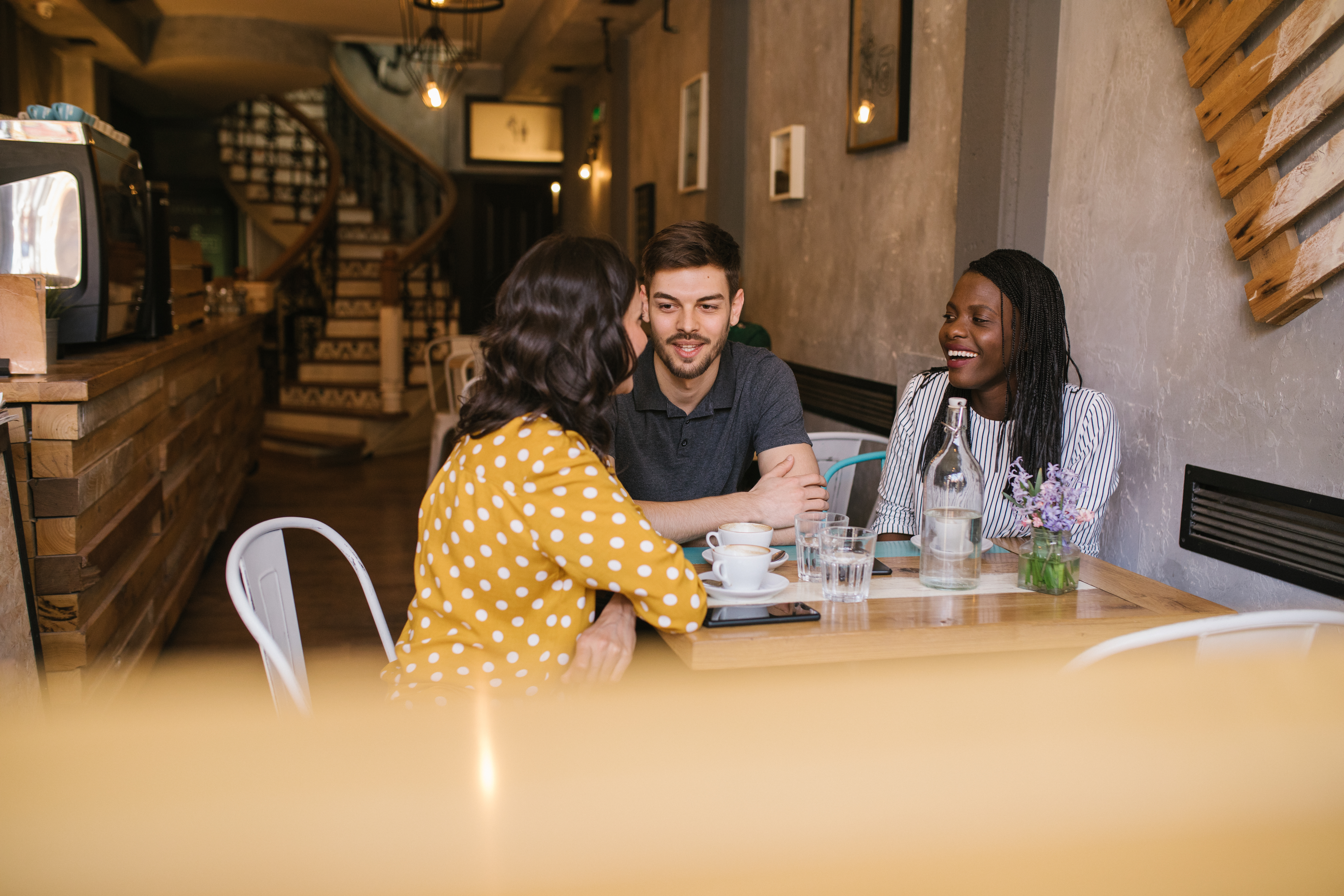 Friends chatting over coffee at a cozy café table.